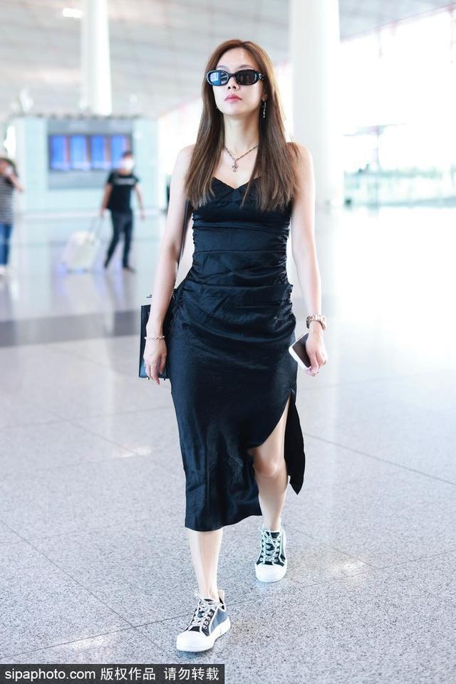 王霏霏戴着墨镜，穿着黑色吊带开叉露背的连衣裙现身，散发出酷感十足的气质。