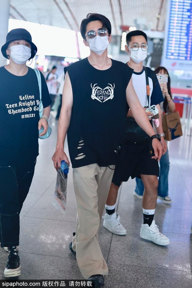 张新成穿黑色无袖T恤搭配现身机场 搭配墨镜酷劲十足
