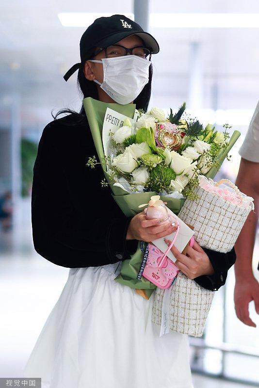 孙怡穿黑色外套搭白色短裙 手捧两束鲜花笑眼弯弯