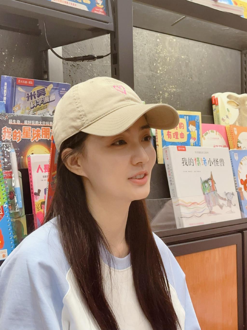 徐璐戴棒球帽造型休闲 坐地上看书乖巧呆萌