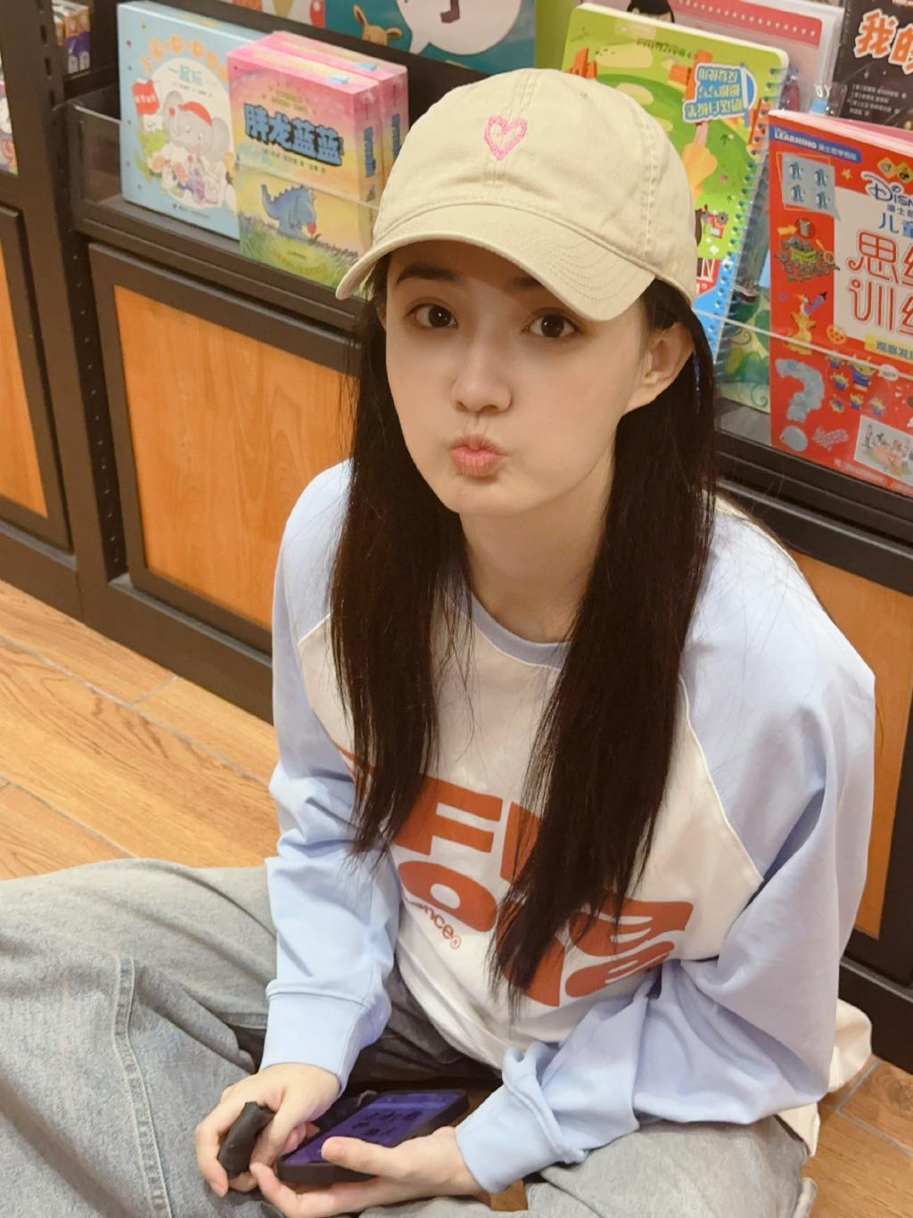 徐璐戴棒球帽造型休闲 坐地上看书乖巧呆萌