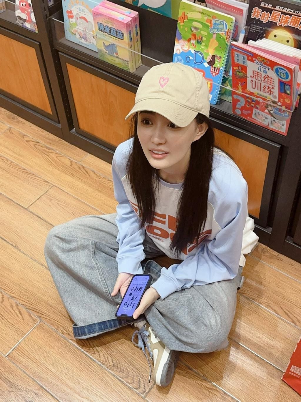 徐璐戴棒球帽造型休闲 坐地上看书乖巧呆萌