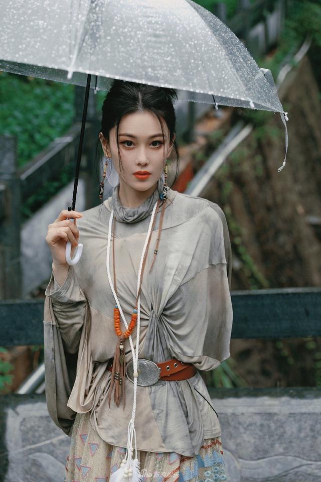 张馨予雨天撑伞写真曝光 抬眸看雨五官精致动人