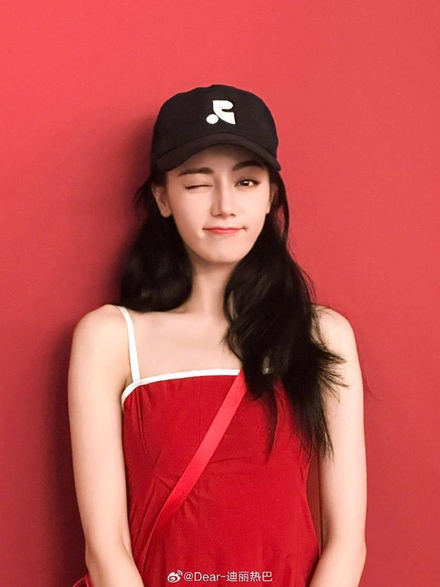 迪丽热巴微博营业晒红裙美照 戴棒球帽对镜甜笑wink