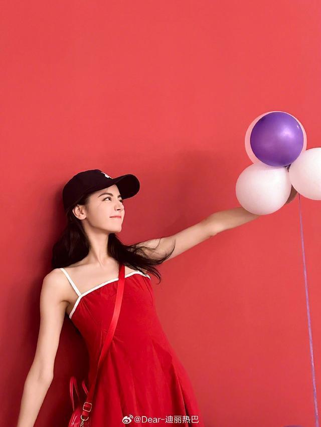 迪丽热巴微博营业晒红裙美照 戴棒球帽对镜甜笑wink