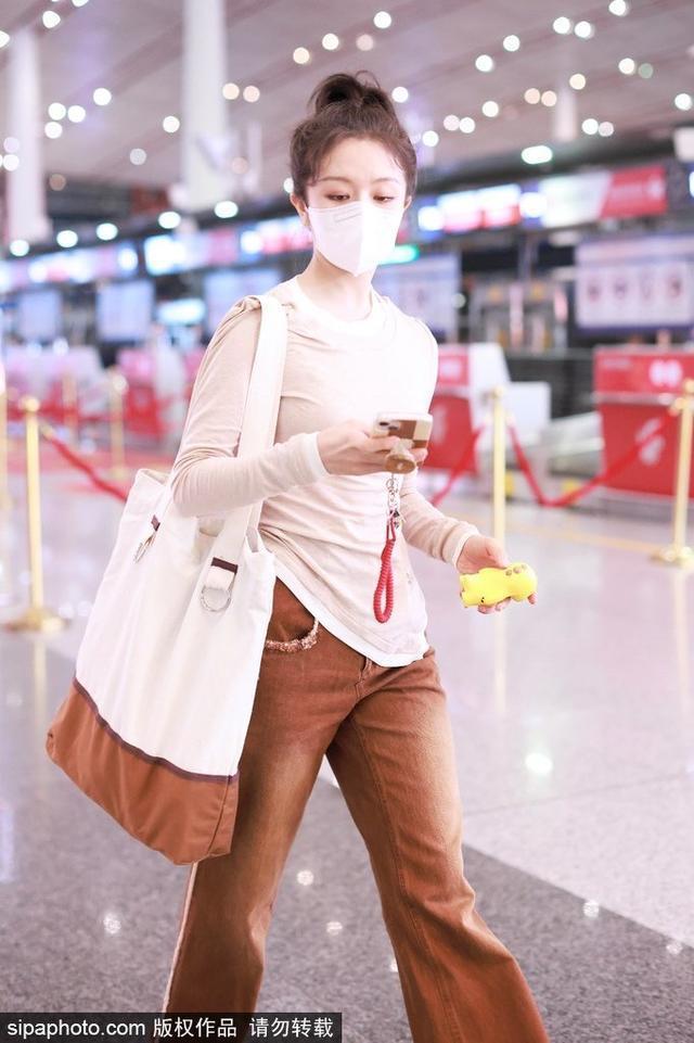 李兰迪穿亚麻色长袖T恤搭配长裤现身机场 简约又时尚