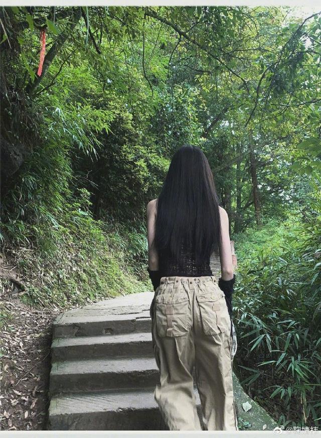 鞠婧祎漫步绿野山林一抹亮色 捧花细嗅蜜语笑颜清澈