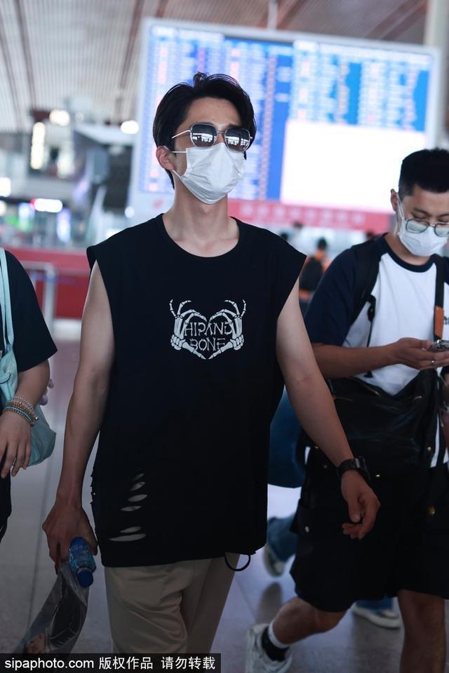 张新成穿黑色无袖T恤搭配现身机场 搭配墨镜酷劲十足