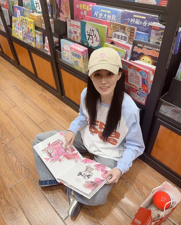 徐璐戴棒球帽造型休闲 坐地上看书乖巧呆萌