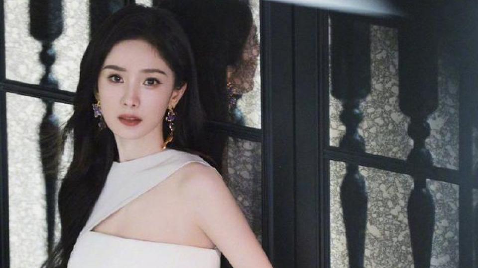 杨幂高开叉白色长裙莞尔动人，花团锦簇中显静谧之美