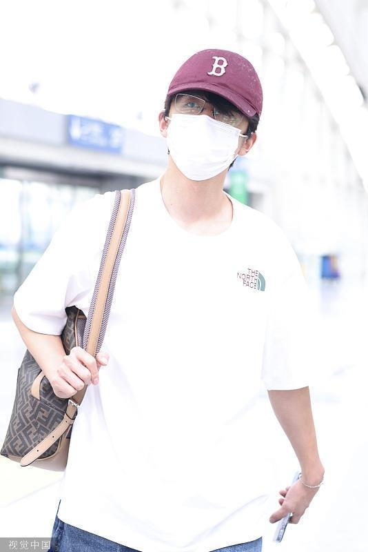 张新成白T恤造型现身首都机场 单肩挎包清爽时尚