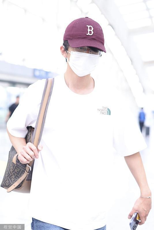 张新成白T恤造型现身首都机场 单肩挎包清爽时尚