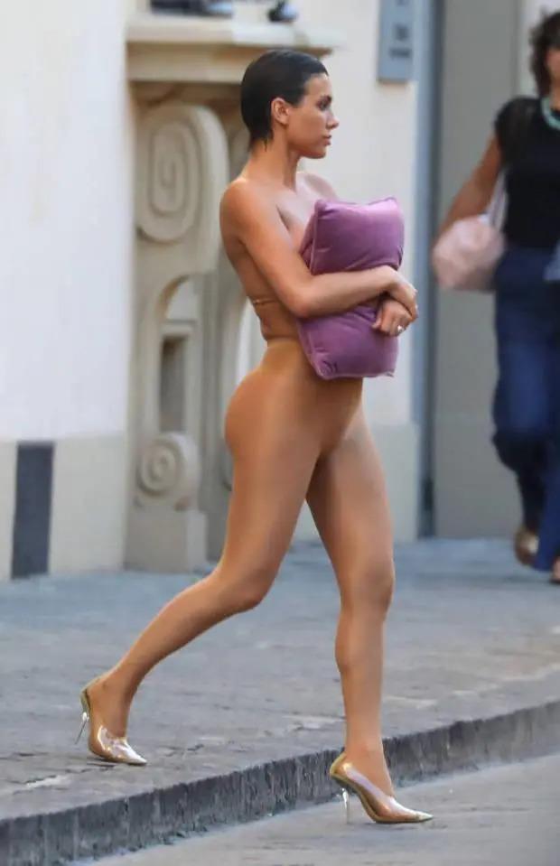 太另类！侃爷老婆又惹争议 裸色紧身服出行抱枕头遮胸