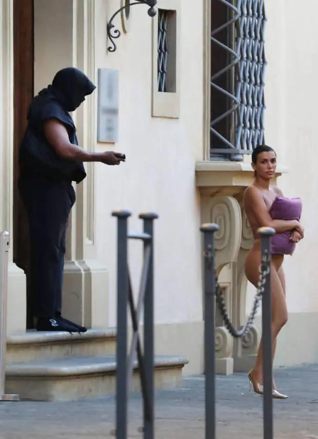 太另类！侃爷老婆又惹争议 裸色紧身服出行抱枕头遮胸