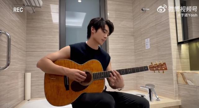 于适浴室弹唱《少年赋》穿无袖上衣抱吉他似校园男神