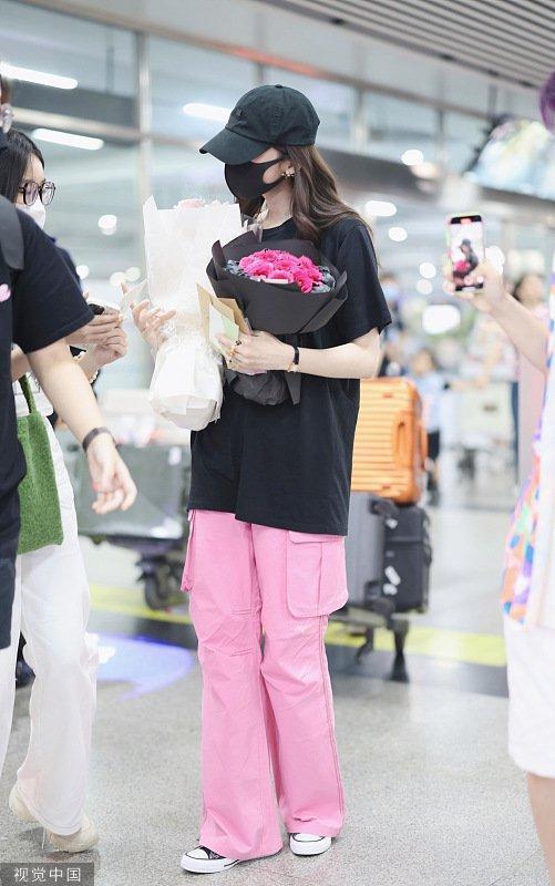 娜扎穿黑色休闲T现身黄花机场 手捧花束引粉丝热情跟拍