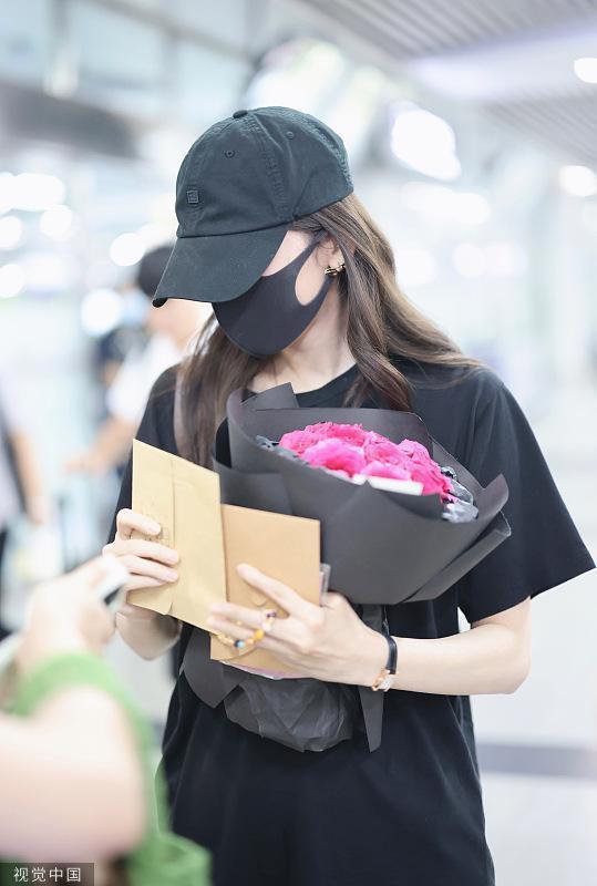 娜扎穿黑色休闲T现身黄花机场 手捧花束引粉丝热情跟拍