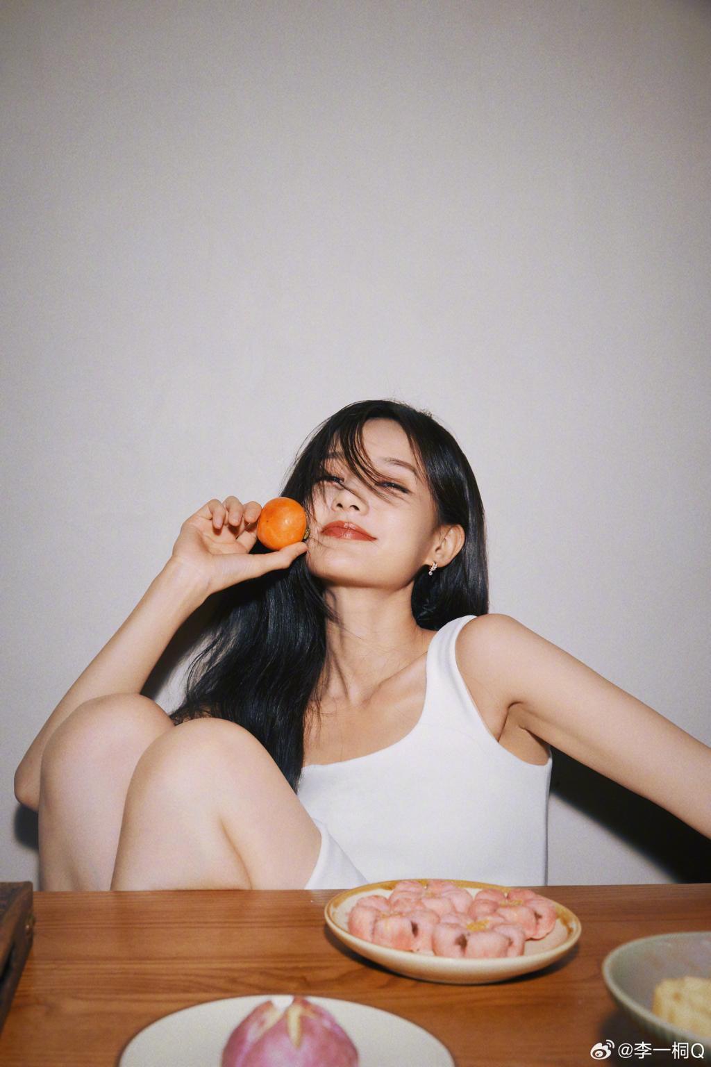 李一桐穿白衣清纯可人 手捧柿子笑容甜美
