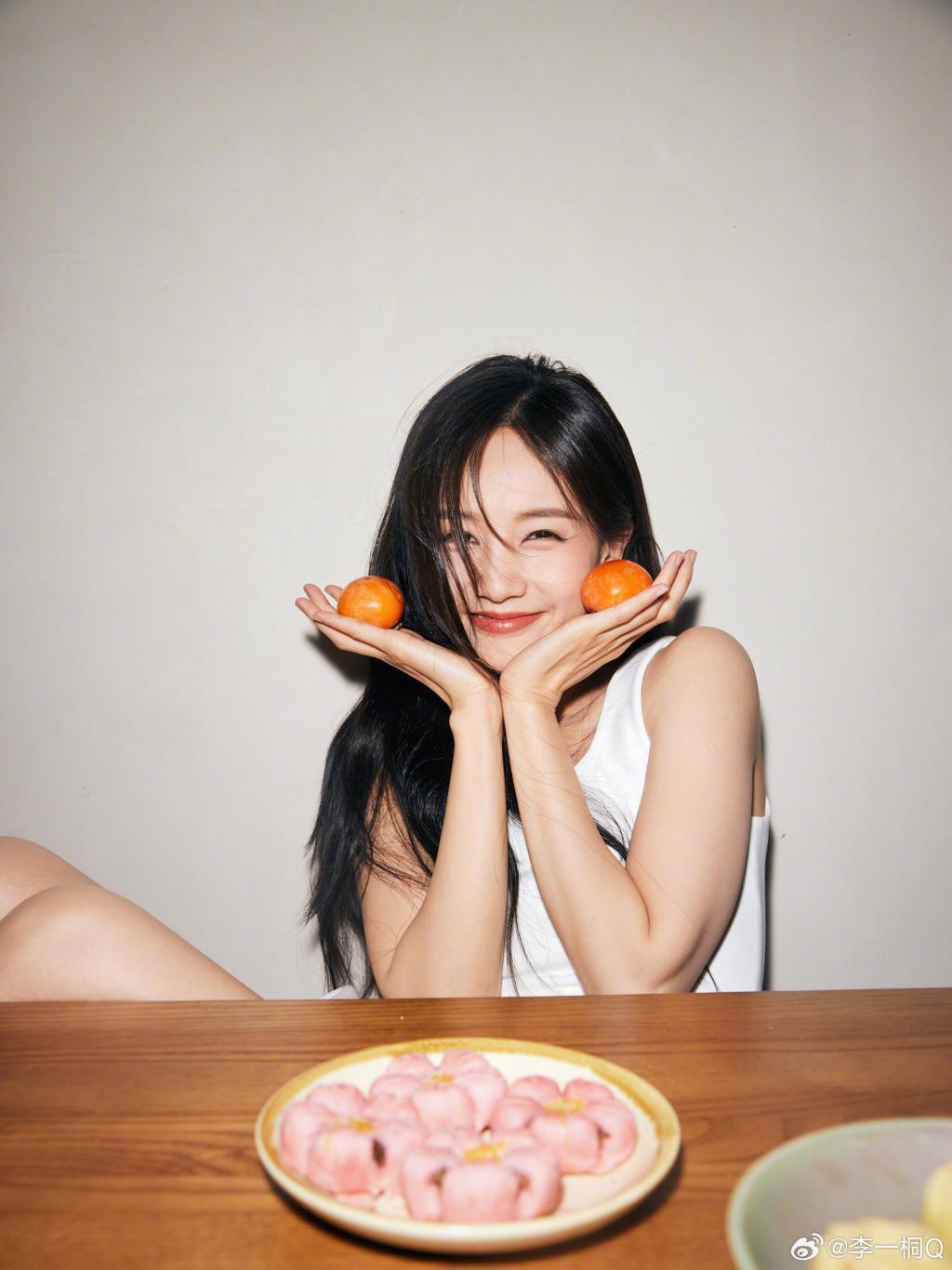 李一桐穿白衣清纯可人 手捧柿子笑容甜美