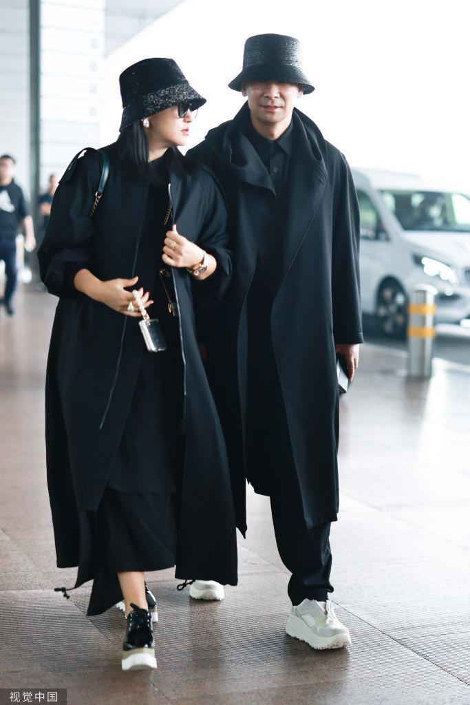 赵文卓夫妇黑大衣造型机场出发 夫妻俩一路牵手恩爱依旧