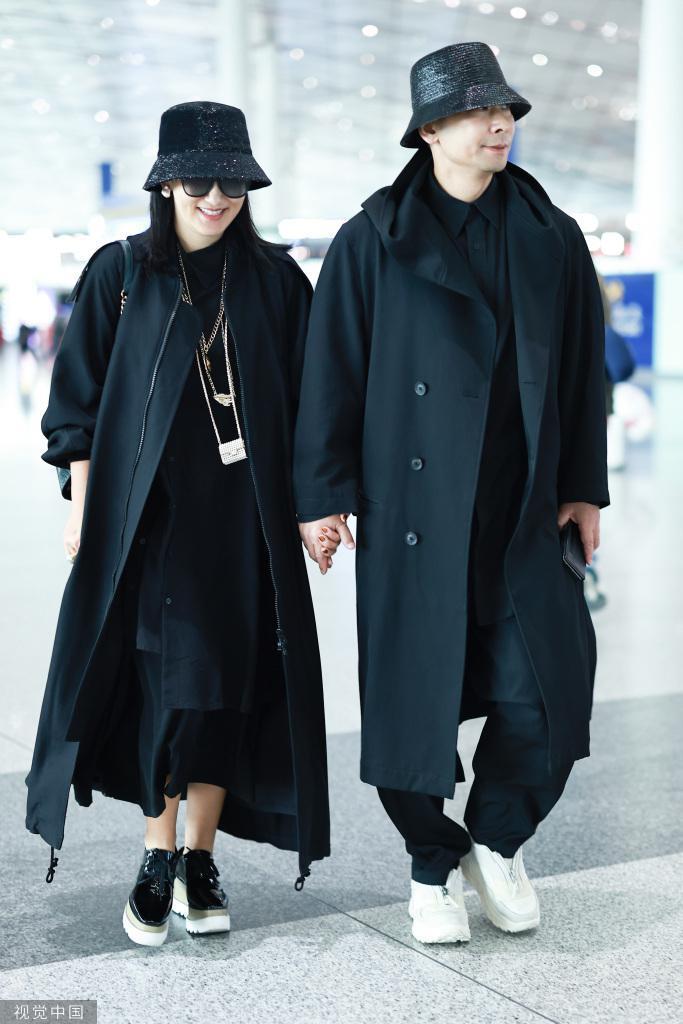 赵文卓夫妇黑大衣造型机场出发 夫妻俩一路牵手恩爱依旧