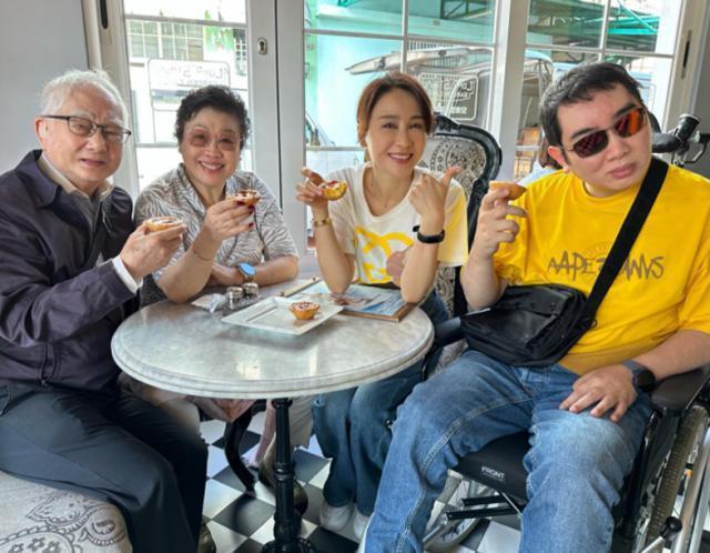 51岁黎姿体力真好，推着弟弟和父亲游澳门，黎婴伸手比耶抢镜头