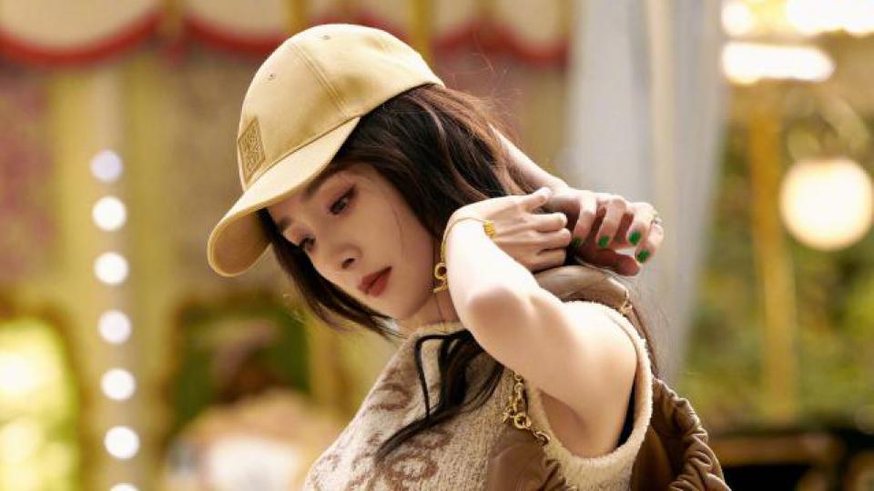 杨幂穿背心配黑裙露蛮腰 戴棒球帽休闲随性