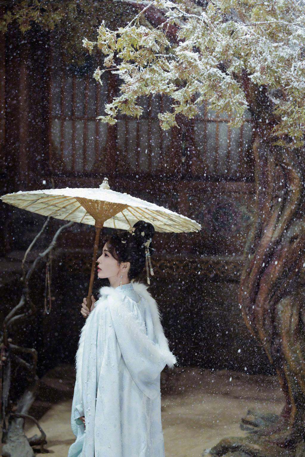 白鹿穿蓝色古装清丽动人 雪中撑伞气质温婉