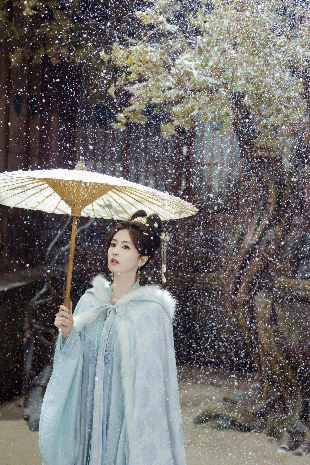 白鹿穿蓝色古装清丽动人 雪中撑伞气质温婉