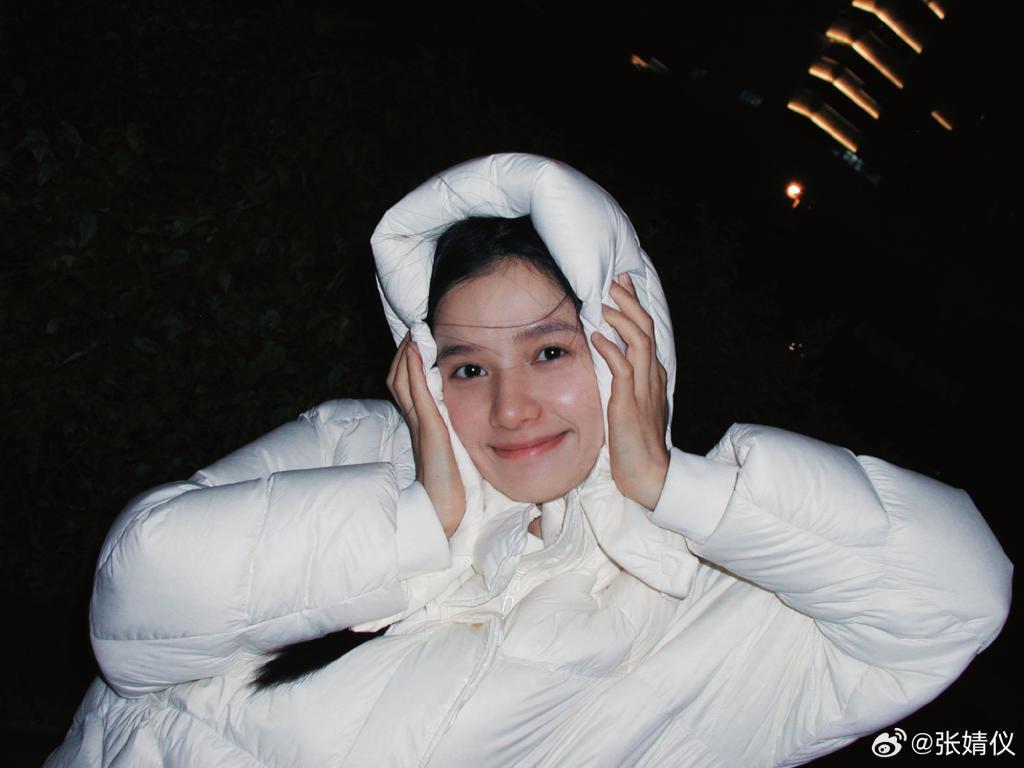 张婧仪裹白色羽绒服露素颜 甜笑歪头比耶