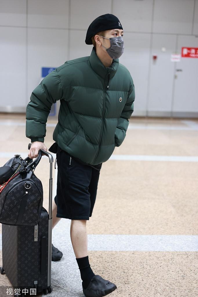 王嘉尔现身机场 身穿绿色棉袄搭配黑色短裤露出小腿