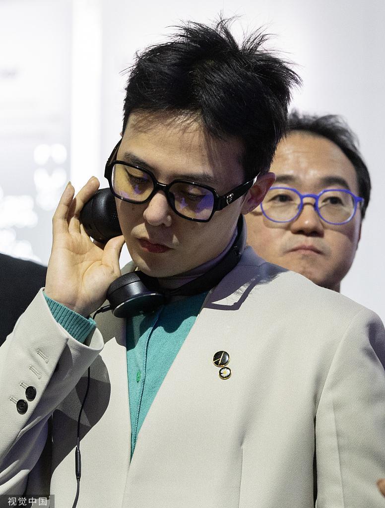 权志龙亮相线下活动 白色西装搭配青色内搭很有风格