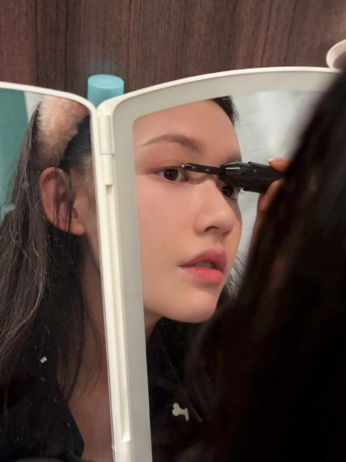 林允晒对镜化妆图 表情可爱灵动