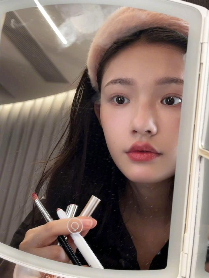 林允晒对镜化妆图 表情可爱灵动